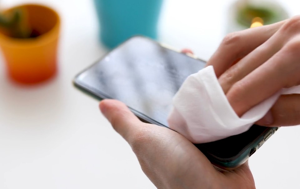 Hand cleaning phone screen with cloth